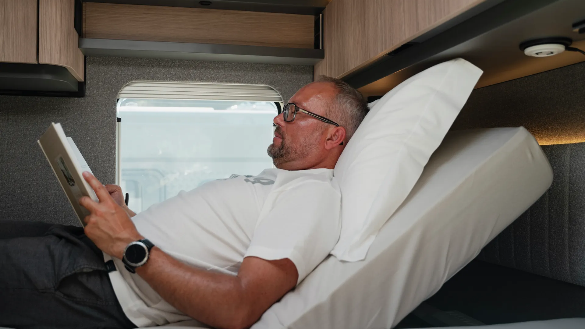 Lesen, entspannen, ankommen: Das elektrisch verstellbare Kopfteilsystem passt die Liegeposition per Handschalter individuell an. Erhältlich über Hymer Original Parts.