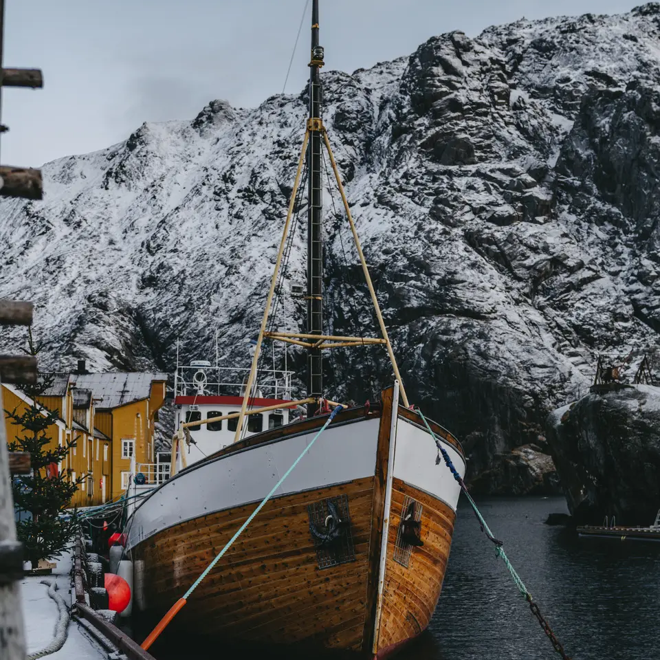 Boot aangemeerd, een grote besneeuwde berg op de achtergrond