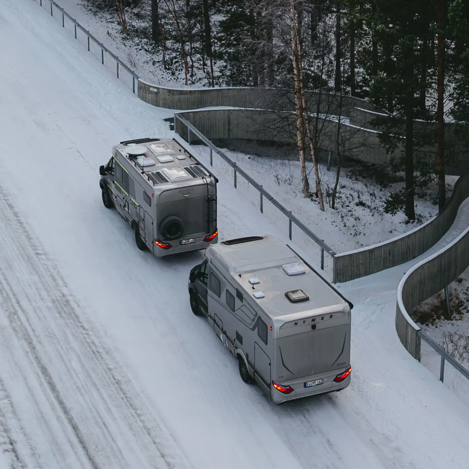 Luchtzicht op HYMER B-MC T BlackLine en HYMER ML-T 570 CrossOver, geparkeerd op een besneeuwde weg
